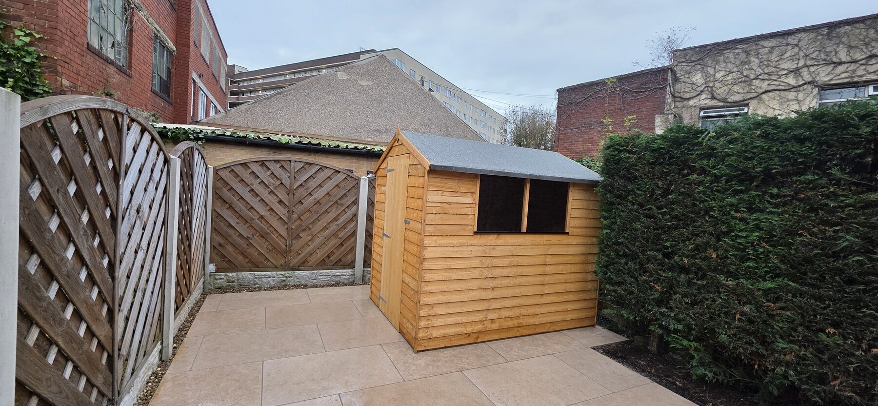 Completed Sahara Pearl garden project: garden with Sahara Pearl paving, planting beds, a retained hedge and garden shed, view 3